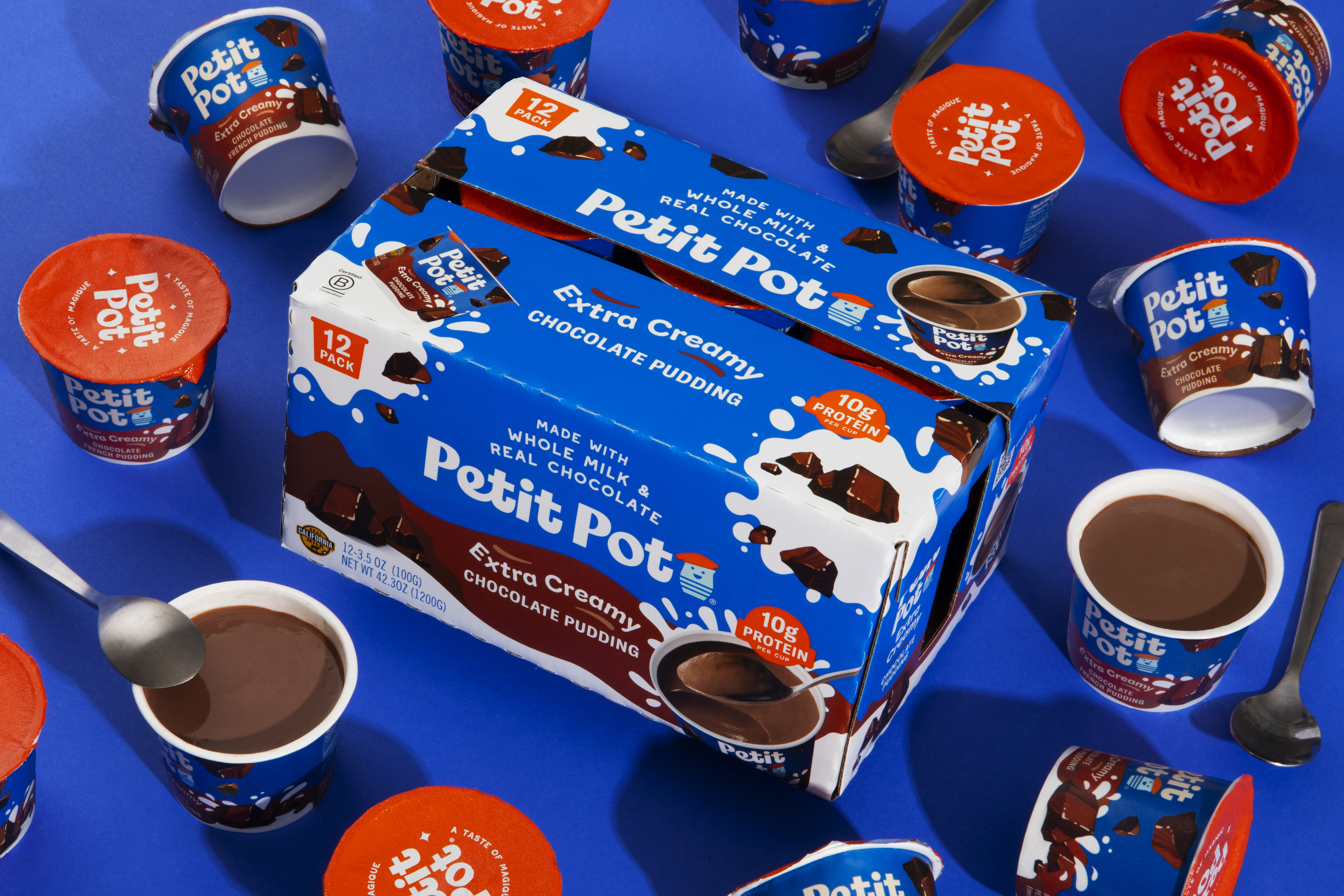 Petit Pot Extra Creamy Chocolate Pudding 12-pack surrounded by individual cups on a blue background